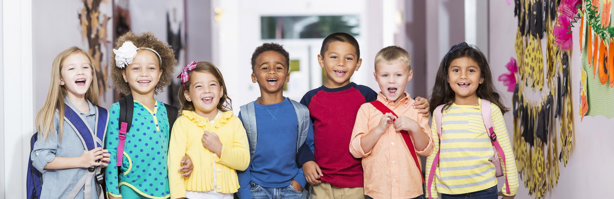 Diverse groud of children standing in a hallway of an elementary school